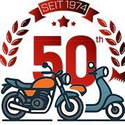 Ein Motorrad und ein Moped vor einem 50-Jahre-Logo
